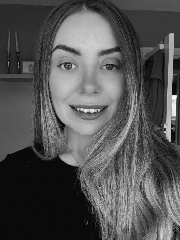 Black and white head and shoulders photograph of a woman smiling at the camera